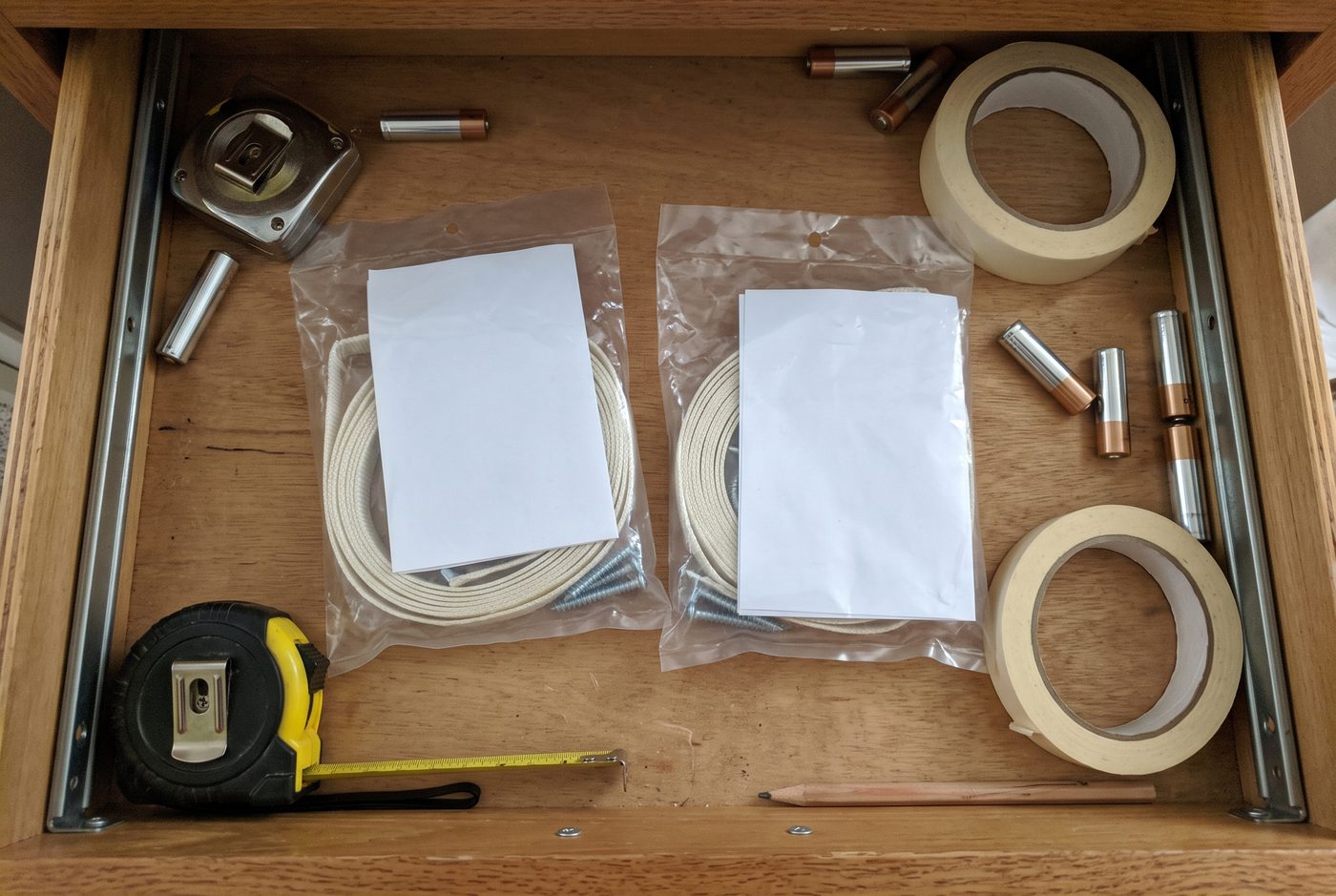 Two sealed furniture anchor kits lying unopened in a household drawer